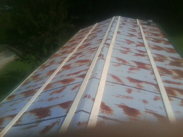 Rusted metal roof panels with new wood purlins before replacement — Storm Damage Roof Repair in De Borgia by Roofing Brothers