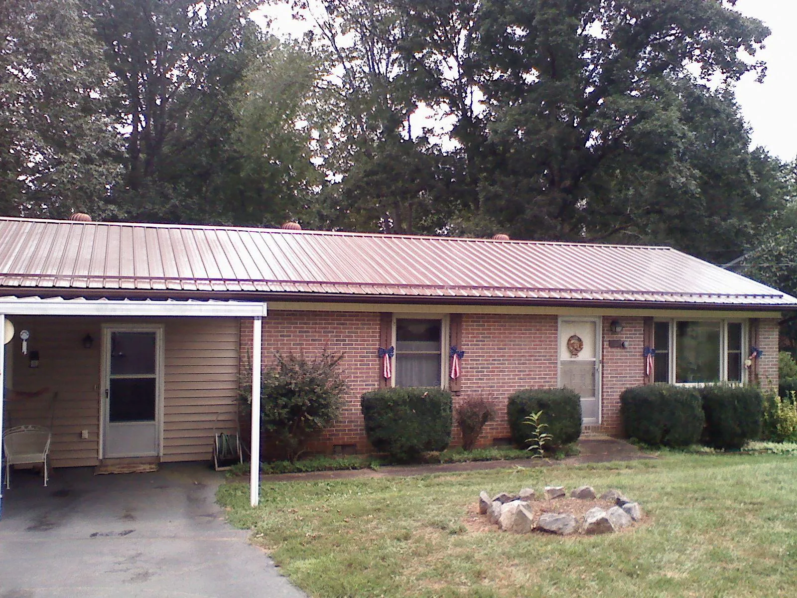 Bronze metal roof and carport on a brick ranch home — Roof Repair work by our crew in De Borgia
