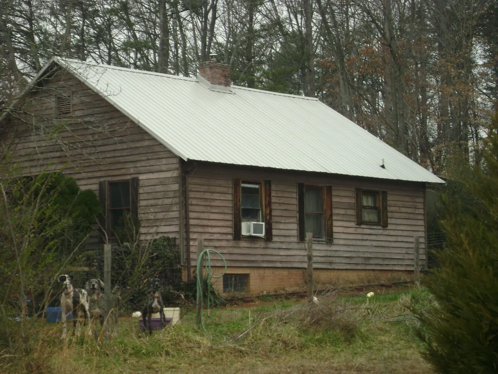 White metal roof on an old wood sided farmhouse, from a Metal Roof Installation job in De Borgia